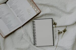 white notebook beside a bible