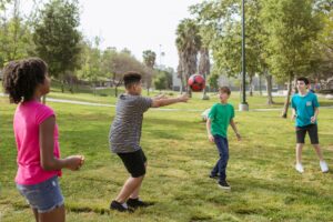 teenagers having fun playing soccer ball on a park