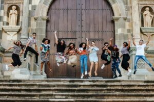 group of young people jumping in the air at the church steps